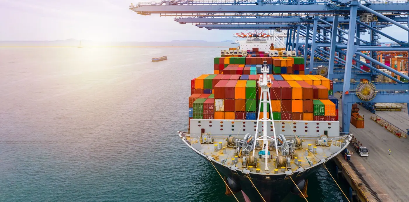 Container ship docked beside gantry cranes at a port